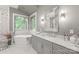 This primary bathroom includes a soaking tub, marble floors, vanity, and window with blinds at 542 Lochaven Rd, Waxhaw, NC 28173