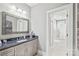 Stylish bathroom with a granite countertop vanity, a large framed mirror, and an open doorway at 542 Lochaven Rd, Waxhaw, NC 28173