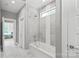 Bright bathroom showcasing a modern tub with glass surround and a view from the window at 542 Lochaven Rd, Waxhaw, NC 28173