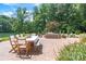Expansive outdoor patio with dining and lounging spaces amidst lush greenery and water views at 542 Lochaven Rd, Waxhaw, NC 28173