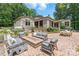 Rear exterior view showcasing outdoor seating around a stone fire pit and the meticulously landscaped grounds at 542 Lochaven Rd, Waxhaw, NC 28173