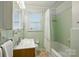 Green bathroom features tiled walls, window, bath tub, and classic fixtures at 576 Scaleybark Rd, Charlotte, NC 28209