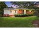 Charming brick home at twilight, featuring a well-manicured lawn and lush landscaping at 576 Scaleybark Rd, Charlotte, NC 28209