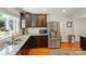 Modern kitchen with stainless steel appliances, granite countertops and dark wood cabinets at 576 Scaleybark Rd, Charlotte, NC 28209