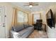 Versatile room featuring a sofa, TV, ceiling fan, and desk setup at 576 Scaleybark Rd, Charlotte, NC 28209
