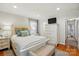 Bright main bedroom with white furniture, TV, patterned pillows, and natural light at 576 Scaleybark Rd, Charlotte, NC 28209