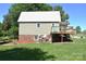 Home's back yard with mature trees, metal roof, and spacious yard at 5769 Birch St, Conover, NC 28613