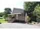View of charming home with a covered porch, wooden deck, gravel parking, and mature trees at 5769 Birch St, Conover, NC 28613