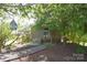 Landscaped front yard featuring mature trees that shade a cozy home with a welcoming front porch at 5769 Birch St, Conover, NC 28613