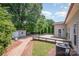 Backyard featuring a wood deck, brick pathway, storage shed, and privacy trees on a sunny day at 618 Circle Trace Rd, Monroe, NC 28110