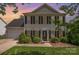 Charming two-story home featuring a classic design, well-manicured lawn, and mature landscaping at sunset at 618 Circle Trace Rd, Monroe, NC 28110