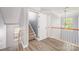 Bright hallway featuring carpeted stairs and wood railing at 618 Circle Trace Rd, Monroe, NC 28110