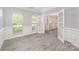 Sunlit room with neutral walls, white trim, wood floors, three windows, and open french doors at 618 Circle Trace Rd, Monroe, NC 28110