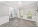 Light-filled living room has gray walls, white wainscoting, and wood-look tile floors at 618 Circle Trace Rd, Monroe, NC 28110