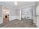 Formal living room showcases gray walls, wainscoting, wood-look tile flooring, and a doorway to the kitchen at 618 Circle Trace Rd, Monroe, NC 28110