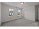 Bright bedroom featuring neutral carpeting, two large windows, and an open doorway at 642 Amberjack Ln, York, SC 29745