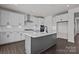 Modern kitchen featuring white cabinets, a gray island, stainless steel appliances, and stylish backsplash at 642 Amberjack Ln, York, SC 29745