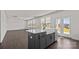 Open-concept kitchen and living space with an island, white cabinets, hardwood floors, and natural light at 642 Amberjack Ln, York, SC 29745