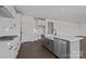 Modern kitchen showcasing white cabinets, gray island, stainless steel appliances and hardwood floors at 642 Amberjack Ln, York, SC 29745