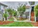 Exterior view of condo with a sidewalk surrounded by green grass, trees, and landscaping at 765 Southwest Dr, Davidson, NC 28036