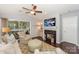 Cozy living room with a fireplace, ceiling fan, sliding glass door to a screened porch, and stylish décor at 765 Southwest Dr, Davidson, NC 28036