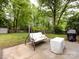Serene backyard with mature trees, a swing bench, a covered container, and lush green grass at 7820 Elm Tree Ln, Charlotte, NC 28227