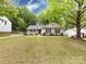 A cozy single-story home with a well-manicured lawn and mature trees provides nice curb appeal at 7820 Elm Tree Ln, Charlotte, NC 28227