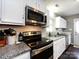 Bright kitchen with white cabinets, granite countertops, and stainless steel appliances at 7820 Elm Tree Ln, Charlotte, NC 28227