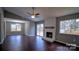 This living room features gleaming hardwood floors, a painted fireplace, and sliding glass doors to the back yard at 7820 Elm Tree Ln, Charlotte, NC 28227