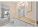 Bright bathroom features a beige vanity with a stone countertop and a large framed mirror at 7822 Village Harbor Dr, Cornelius, NC 28031