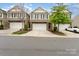 Charming townhome featuring stone accents, a two-car garage, and manicured landscaping at 832 Summerlake Dr, Fort Mill, SC 29715