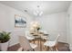 Elegant dining room with modern decor, featuring a glass table, chandelier, and decorative artwork at 8322 Summerglen Cir, Charlotte, NC 28227