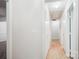 Bright hallway with clean white walls and light wood-look flooring, illuminated by ceiling lights at 8322 Summerglen Cir, Charlotte, NC 28227