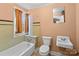 Full bathroom featuring an orange wall and accent tile, a standard tub and toilet and a sink at 834 Murphy St, Kannapolis, NC 28081