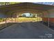Covered carport with a concrete floor, offering protection for vehicles with views of the backyard at 834 Murphy St, Kannapolis, NC 28081
