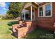 Brick porch with steps leading to the front door, enhanced by lattice trim and columns, with a manicured lawn at 834 Murphy St, Kannapolis, NC 28081