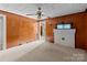 Living room with white fireplace, vintage ceiling fan, wood paneled walls, and view to another room at 834 Murphy St, Kannapolis, NC 28081