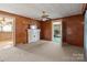 Spacious living room with brick fireplace, vintage ceiling fan, and views to a porch and another room at 834 Murphy St, Kannapolis, NC 28081
