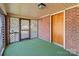 Enclosed front porch featuring brick accents and a screened entryway at 834 Murphy St, Kannapolis, NC 28081