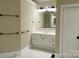 Spacious bathroom with dual sinks, white cabinetry, tile floors and a large mirror and vanity lighting at 9113 Oak Bluff Ct, Waxhaw, NC 28173