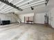Spacious garage with concrete floor, stairs, storage rack, and water heater at 9113 Oak Bluff Ct, Waxhaw, NC 28173