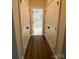 Hallway view leading to bathroom with double doors, dark flooring, and bright tile in bathroom at 9113 Oak Bluff Ct, Waxhaw, NC 28173