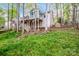 Exterior view of home with elevated wooden deck and sunroom addition overlooking the wooded backyard at 1050 Emerson Dr, Mooresville, NC 28115