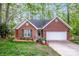 Charming single-story brick home with attached garage, manicured lawn, and mature trees providing shade at 1050 Emerson Dr, Mooresville, NC 28115