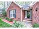 Close-up of front entrance featuring brick facade, welcome mat, and well-maintained landscaping at 1050 Emerson Dr, Mooresville, NC 28115