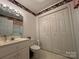 Cozy bathroom that includes a single sink, toilet, and a mirrored vanity and a closet at 1224 Island Creek Dr, Troy, NC 27371