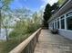 Exterior deck featuring a rustic wooden railing and serene views of the water at 1224 Island Creek Dr, Troy, NC 27371
