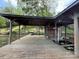 Exterior shot of a covered boathouse and wood dock with seating overlooking a lake at 1224 Island Creek Dr, Troy, NC 27371