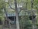 Wood home exterior with multiple windows and outdoor deck nestled among mature trees at 1224 Island Creek Dr, Troy, NC 27371