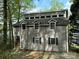 Gray two-story home with dormer windows, black shutters, and water view surrounded by mature trees at 1224 Island Creek Dr, Troy, NC 27371